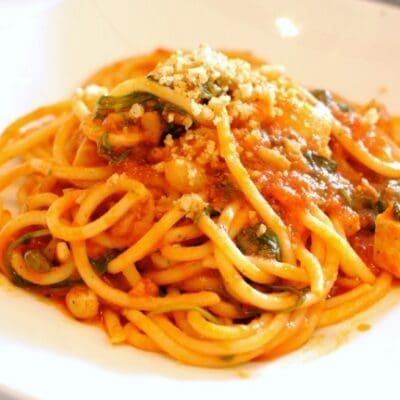 Spaghetti con sugo rosso di pesce spada uvetta pinoli pomodoro e basilico