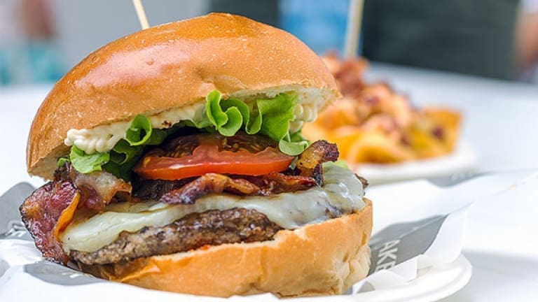 Gourmet burgers with bacon, meat, guacamole, Cheddar, and caramelized onions 